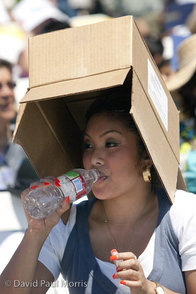 Christel Gellidon of San Francisco braves the heat under a box before First Lady Michelle Obama makes her commencement speech at the University of California, Merced