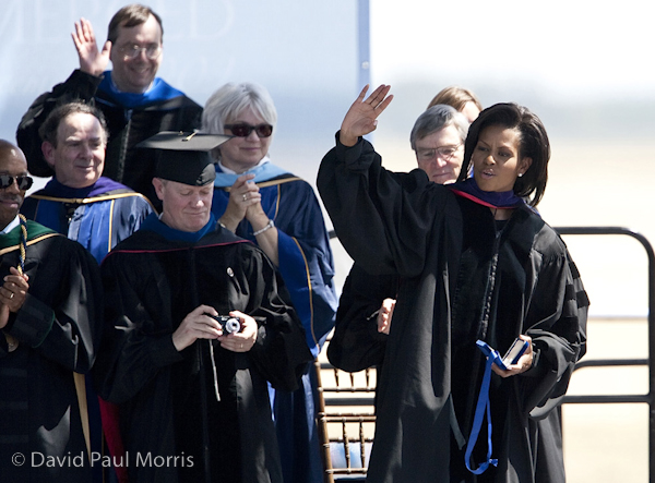 First Lady Michelle Obama waves to the crowd as she leaves while others wave back and try to get a photogaph.