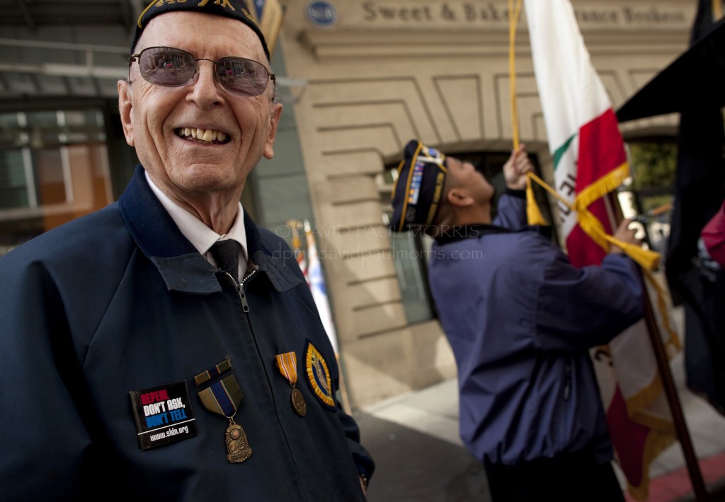 veterans Paul Goercke, 83, a veteran of World War II (L) waits as Dale Pellegrino prepares the flags before the Veterans Day Parade.