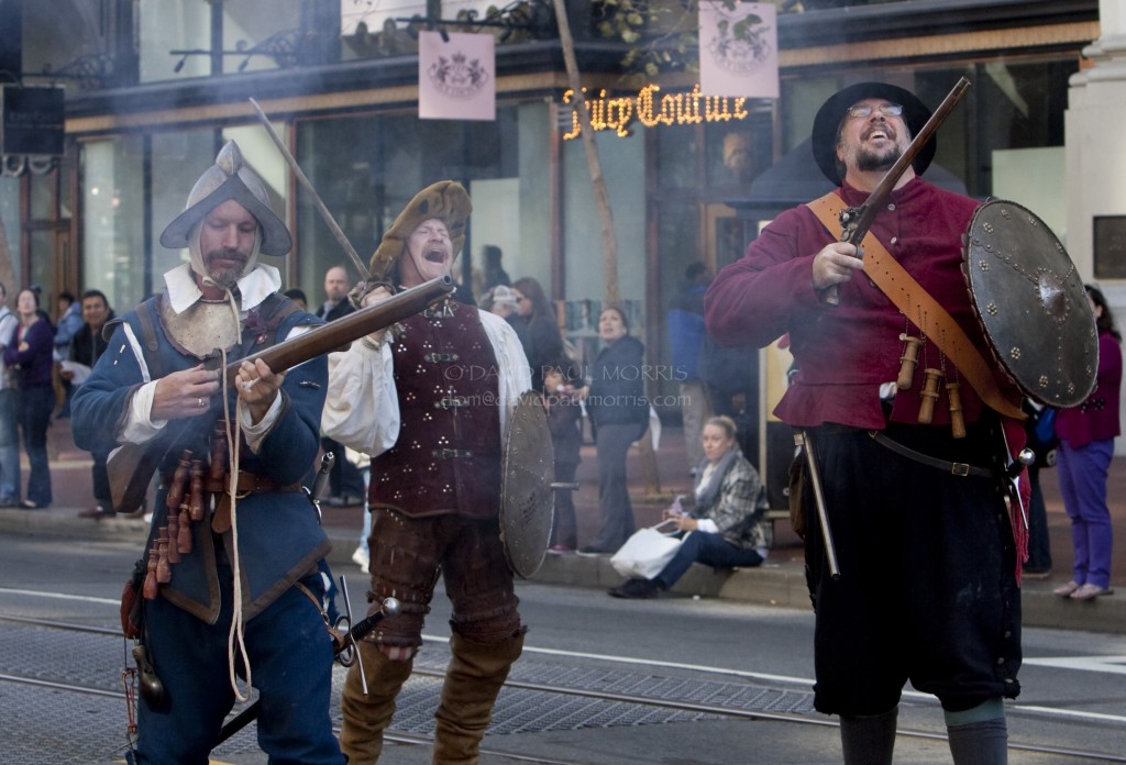 veterans Brien McLaughlin, Steven Moffatt and William Mills members of the Renaissance Military Society laugh as they march down Market Street during the Veterans Day Parade.